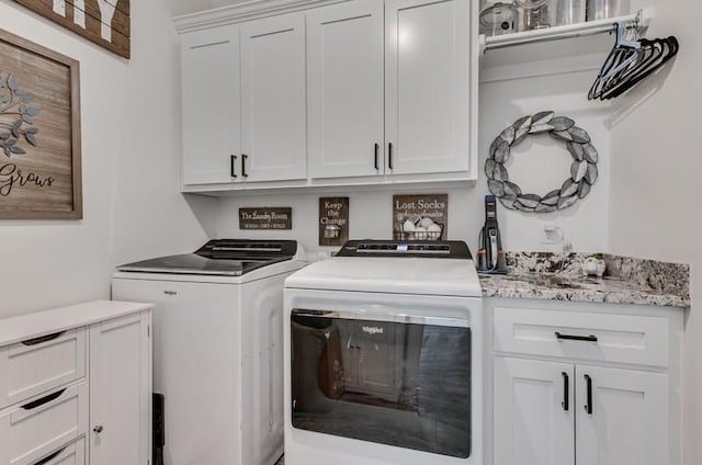 laundry area featuring washer and dryer and cabinets