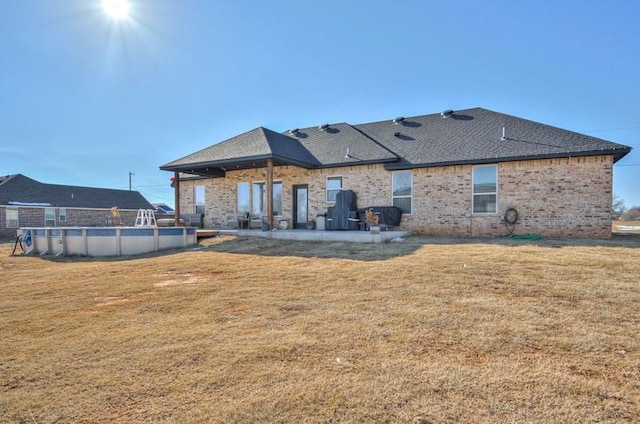 rear view of property with a patio and a yard