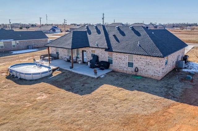 back of house with a patio area, central AC unit, and a lawn