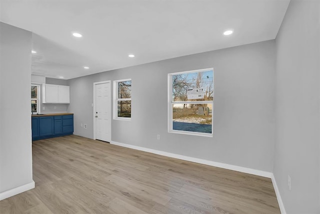 interior space featuring light wood-type flooring, white cabinetry, and blue cabinets