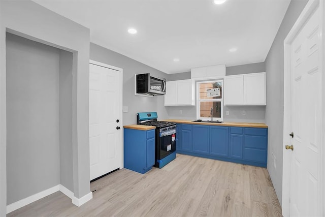 kitchen with sink, wood counters, white cabinetry, and appliances with stainless steel finishes