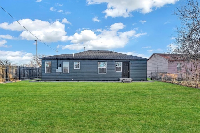 rear view of property featuring a lawn