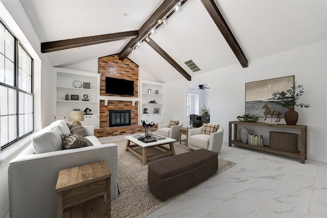 living room with ceiling fan, a brick fireplace, vaulted ceiling with beams, and built in shelves