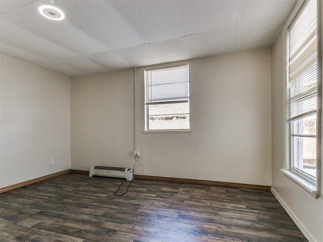 spare room with a drop ceiling and dark wood-type flooring