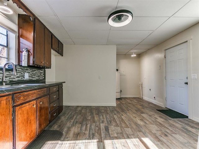 kitchen featuring sink, dark wood-type flooring, tasteful backsplash, and a drop ceiling