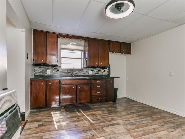 kitchen featuring sink, a drop ceiling, heating unit, and dark brown cabinets