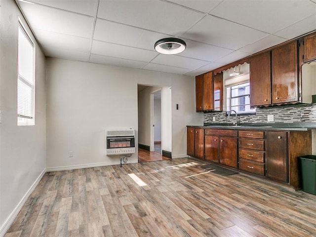 kitchen featuring heating unit, wood-type flooring, a paneled ceiling, decorative backsplash, and sink