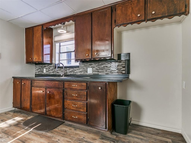 kitchen featuring sink, dark hardwood / wood-style floors, decorative backsplash, and a drop ceiling