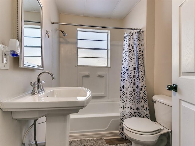 bathroom featuring toilet, shower / bath combination with curtain, and plenty of natural light