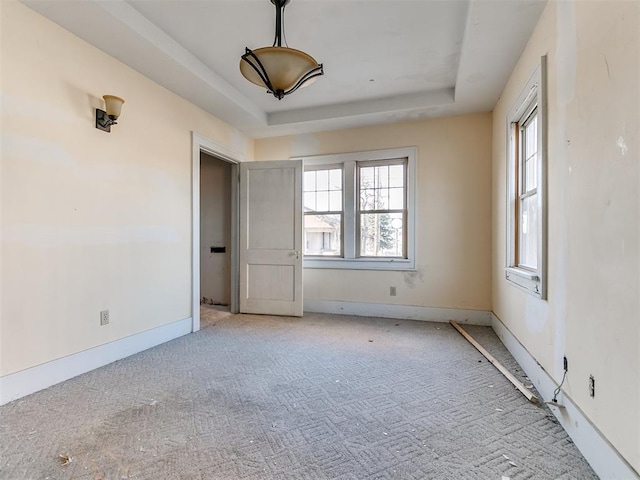 unfurnished room featuring a raised ceiling