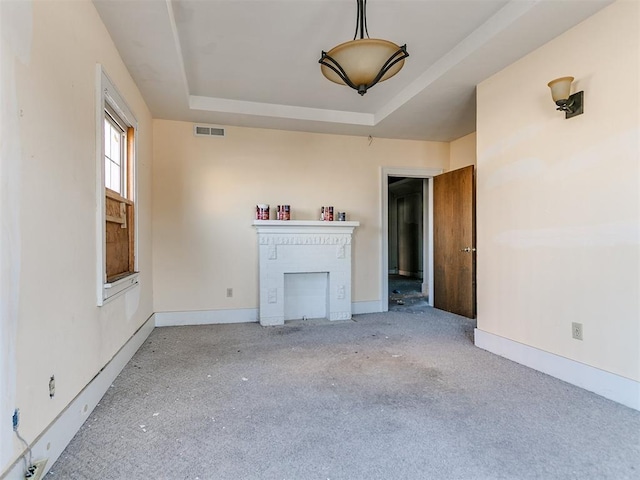 unfurnished living room with a tray ceiling