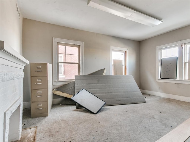 bedroom with a brick fireplace and multiple windows