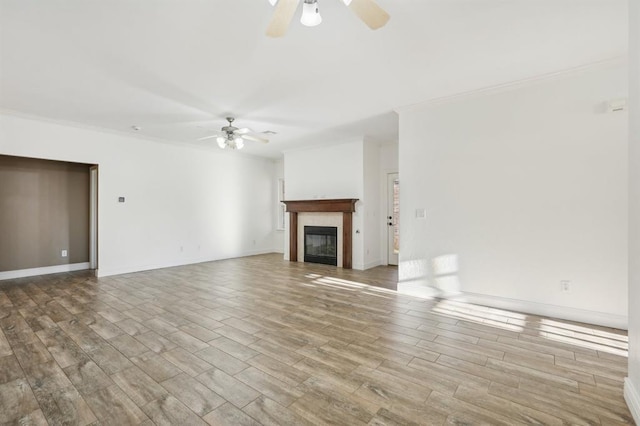 unfurnished living room with ceiling fan, crown molding, and light wood-type flooring