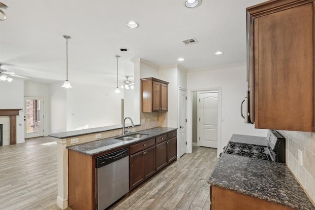 kitchen with ceiling fan, appliances with stainless steel finishes, decorative light fixtures, light wood-type flooring, and sink