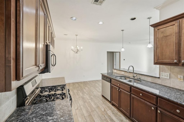 kitchen with stainless steel appliances, sink, hanging light fixtures, a chandelier, and light hardwood / wood-style flooring