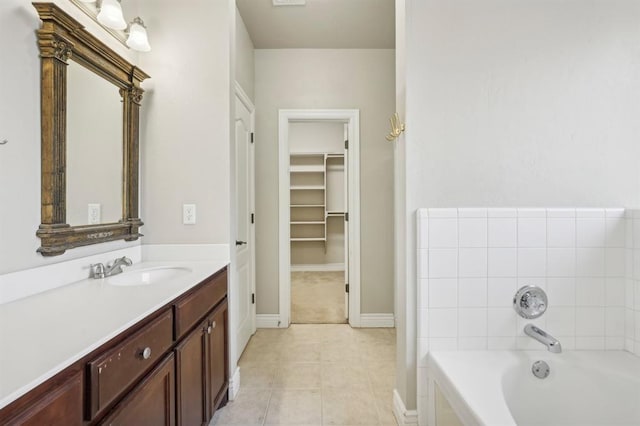 bathroom with tile patterned floors, a bathtub, and vanity