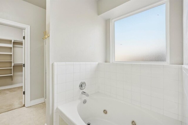 bathroom featuring tiled bath and tile patterned flooring