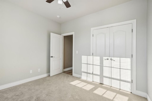 unfurnished bedroom with ceiling fan, light carpet, and a closet