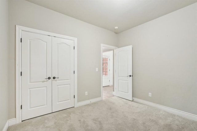 unfurnished bedroom with a closet and light carpet