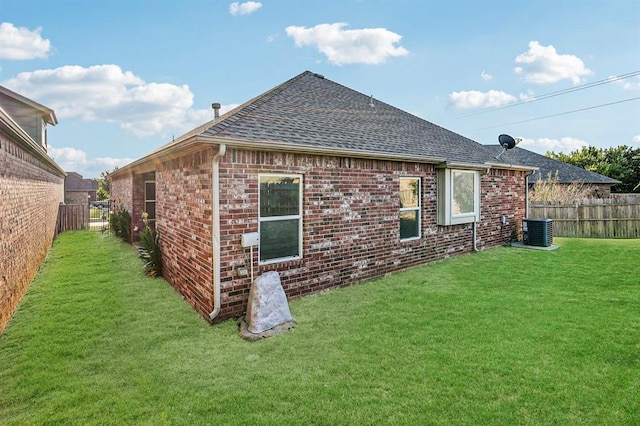 back of house with a lawn and central AC unit