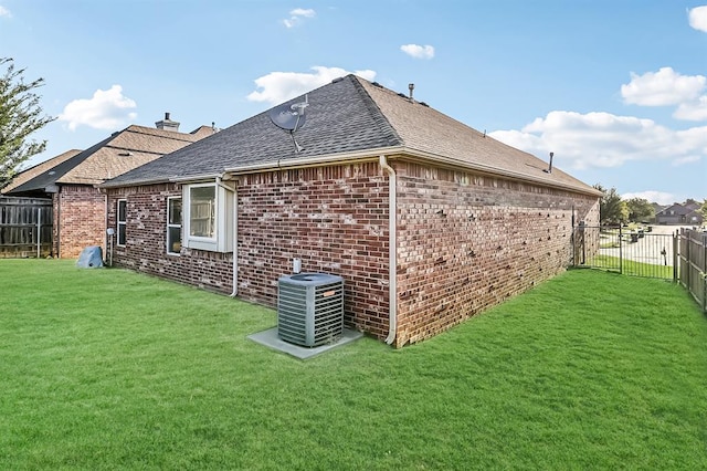 view of side of home featuring central AC and a yard