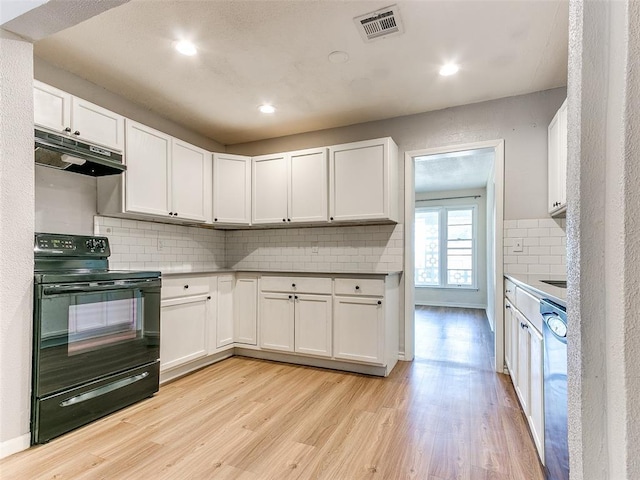 kitchen featuring white cabinetry, black electric range oven, tasteful backsplash, light hardwood / wood-style floors, and stainless steel dishwasher