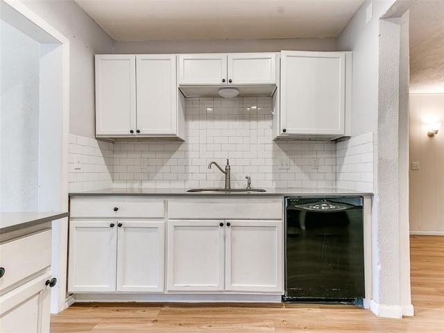 kitchen with sink, decorative backsplash, black dishwasher, and light hardwood / wood-style flooring