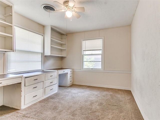 unfurnished office featuring ceiling fan and light colored carpet