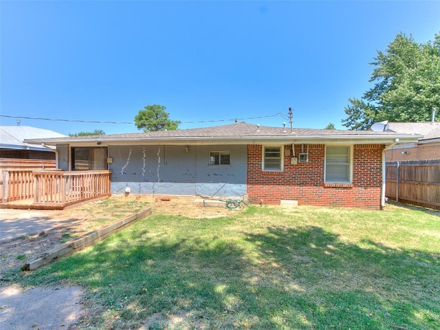 rear view of house featuring a deck and a lawn