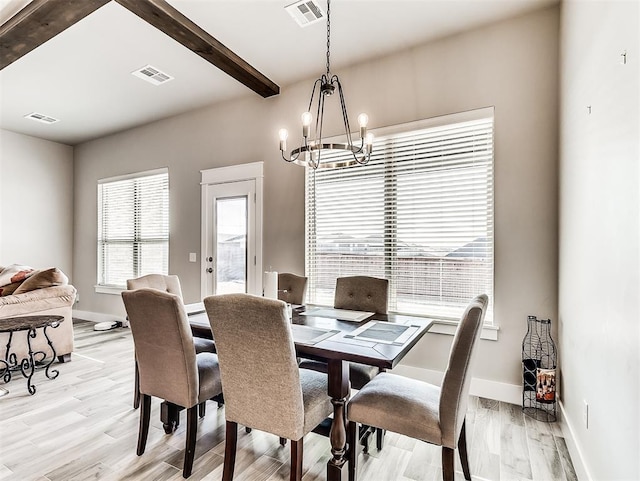 dining area featuring light hardwood / wood-style flooring, beam ceiling, and a chandelier