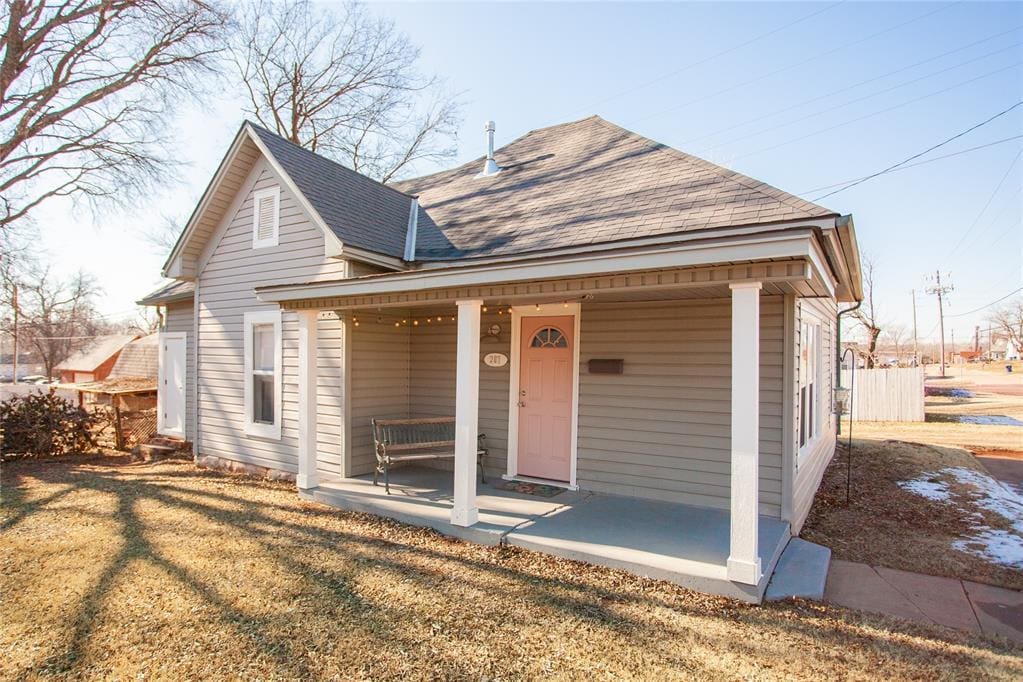 view of front of house with covered porch and a front lawn