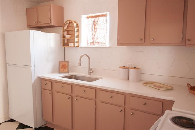 kitchen featuring light brown cabinetry, white refrigerator, tasteful backsplash, and sink