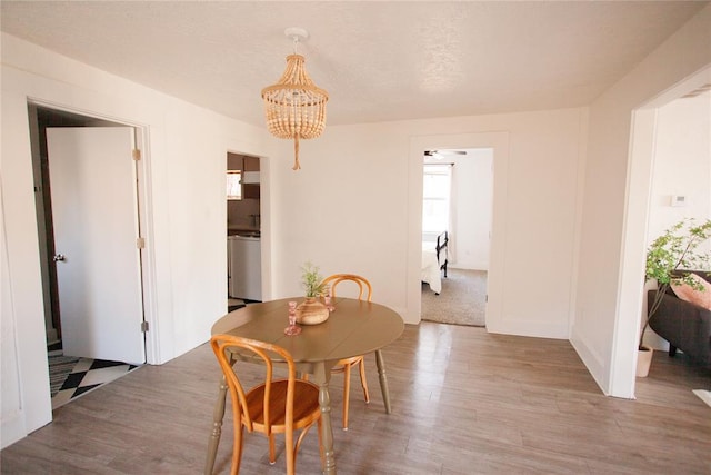 dining space with an inviting chandelier and hardwood / wood-style flooring