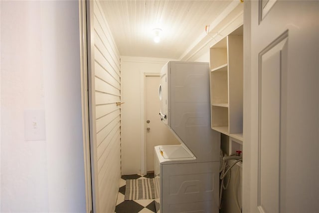 clothes washing area featuring stacked washing maching and dryer