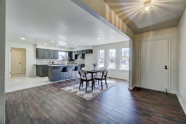 dining space with dark wood-type flooring and a wealth of natural light