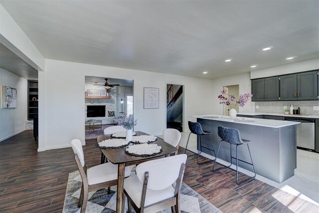 dining room with ceiling fan and a fireplace