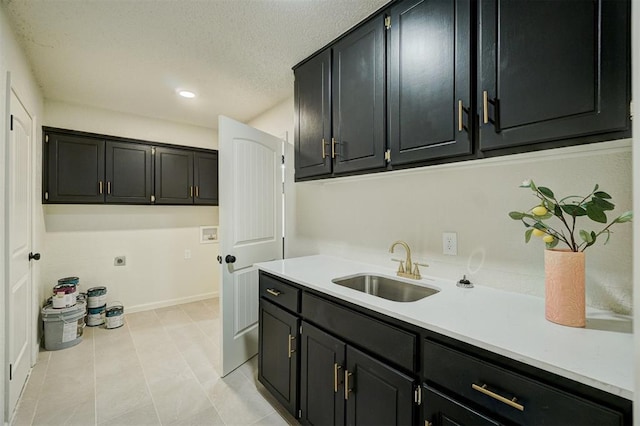 clothes washing area featuring sink, electric dryer hookup, washer hookup, cabinets, and light tile patterned flooring