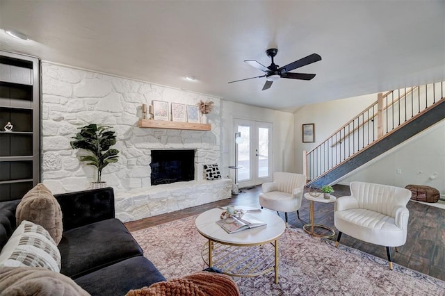 living room featuring a fireplace, ceiling fan, french doors, and hardwood / wood-style floors