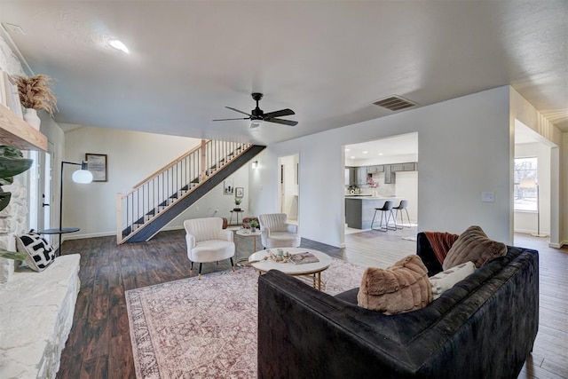 living room with ceiling fan and dark wood-type flooring