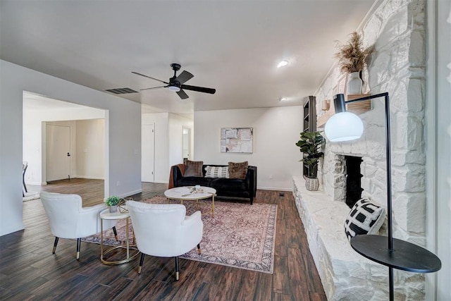 living room featuring dark hardwood / wood-style flooring, a fireplace, and ceiling fan