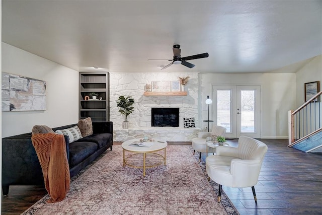 living room with hardwood / wood-style floors, ceiling fan, french doors, a fireplace, and built in features