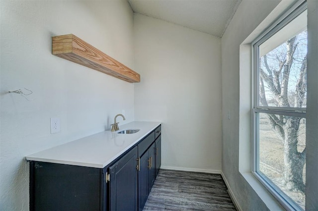 bar with lofted ceiling, dark wood-type flooring, and sink