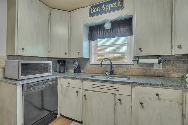 kitchen with sink, light hardwood / wood-style floors, backsplash, and black dishwasher