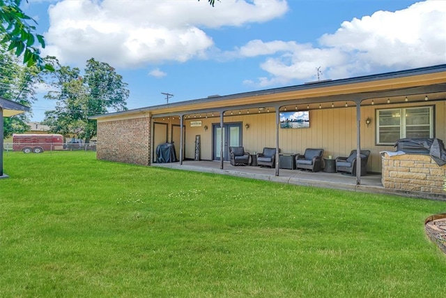 rear view of property featuring a patio, a lawn, and an outdoor living space