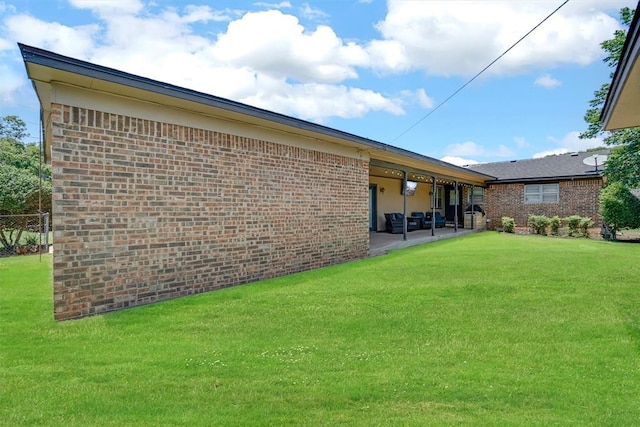 rear view of property featuring a lawn and a patio