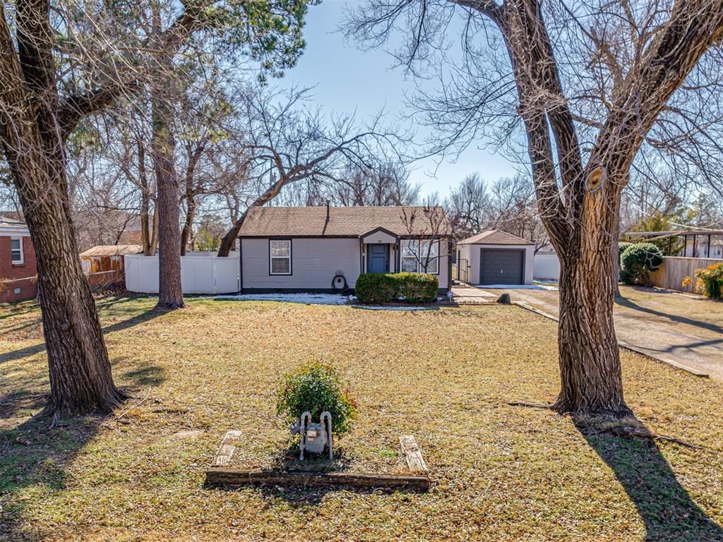 single story home featuring a front lawn and a garage