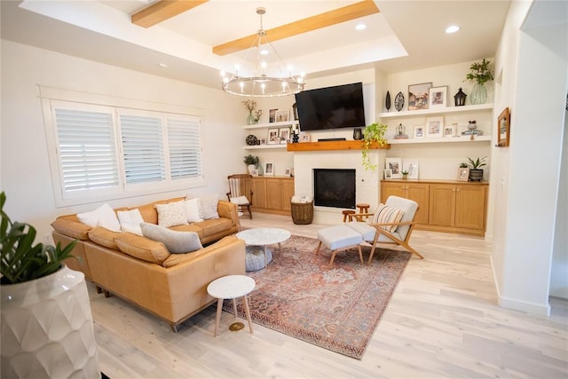 living room featuring a tray ceiling, light hardwood / wood-style floors, and a chandelier