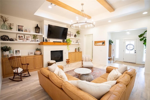 living room with a chandelier, beamed ceiling, a raised ceiling, and light wood-type flooring