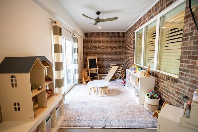 interior space featuring ceiling fan and brick wall