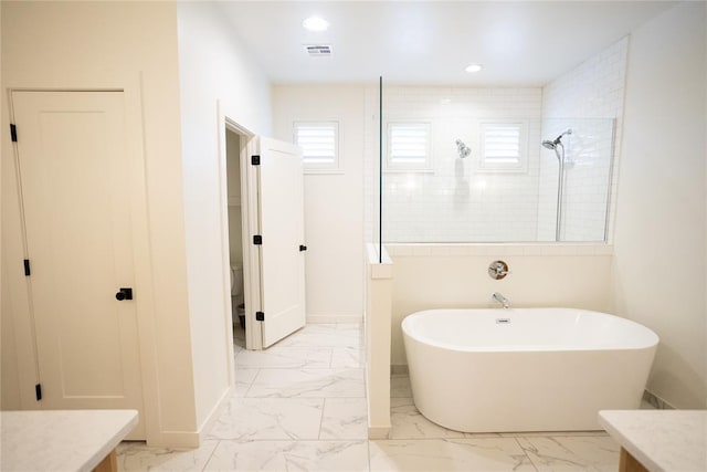 bathroom featuring vanity and independent shower and bath